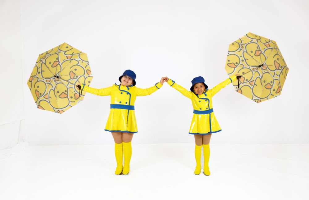 Two young dancers with yellow umbrellas