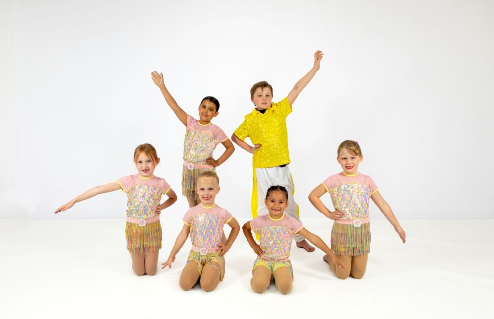 Pre-dance class posed in gold costumes