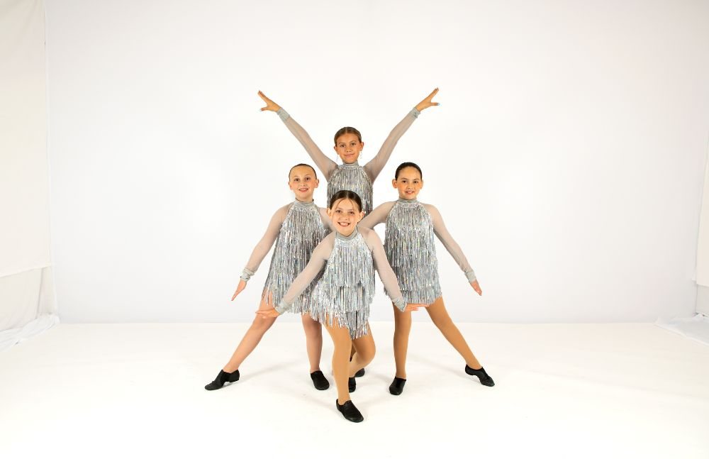 Three tap dancers in silver costumes
