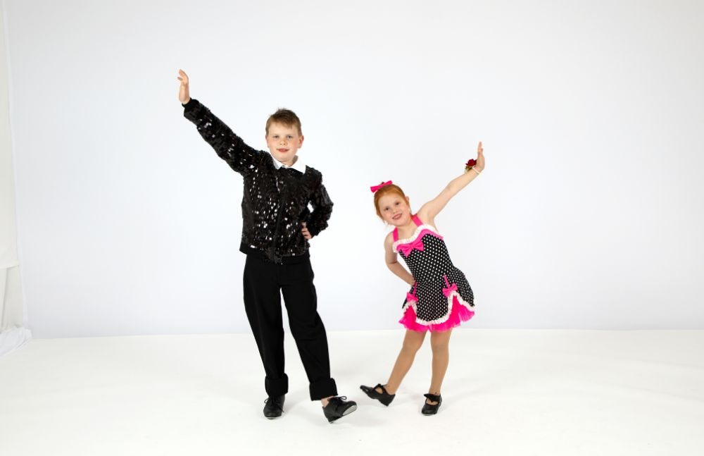 A duo mid-routine in black and pink costumes